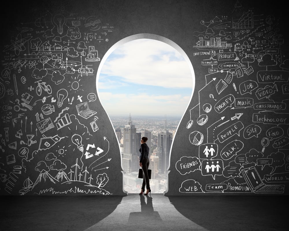 Silhouette of businesswoman against black wall with key hole